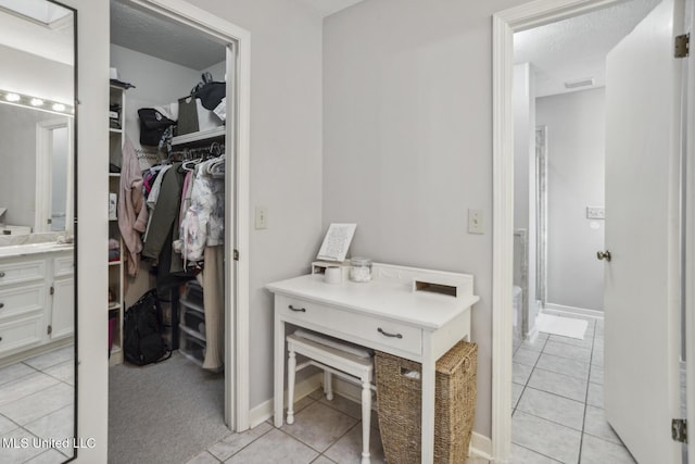 bathroom featuring tile patterned flooring, vanity, an enclosed shower, and a textured ceiling