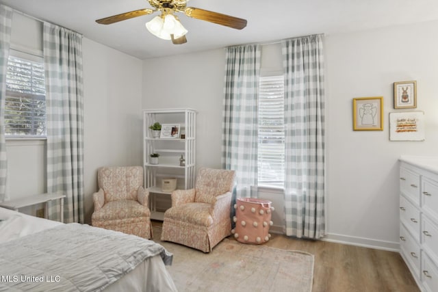 bedroom with ceiling fan, multiple windows, and light hardwood / wood-style flooring