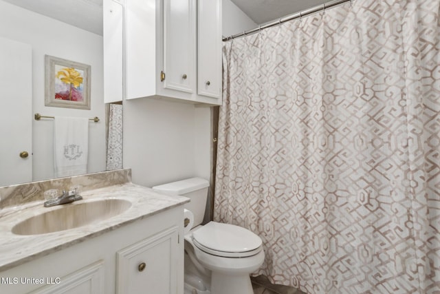 bathroom featuring vanity, a shower with shower curtain, a textured ceiling, and toilet