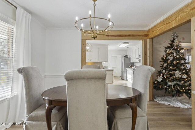 dining room featuring crown molding, wood-type flooring, sink, and an inviting chandelier