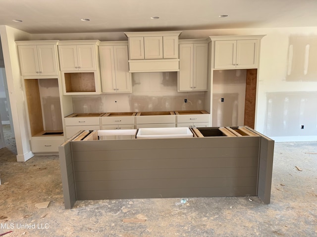 kitchen with white cabinetry, backsplash, and a kitchen island