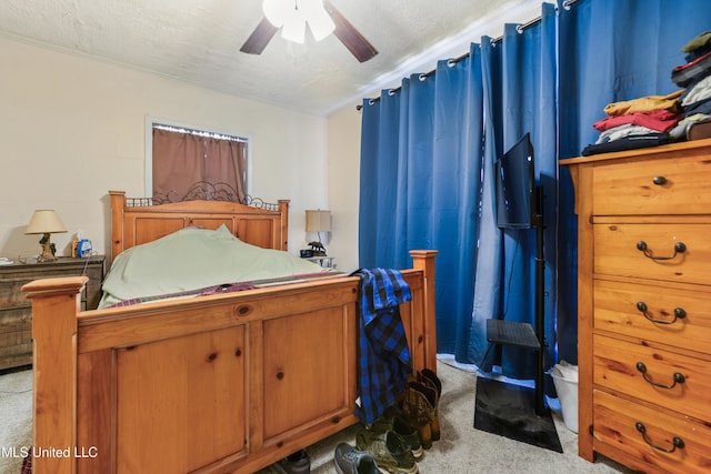 carpeted bedroom featuring ceiling fan and a textured ceiling