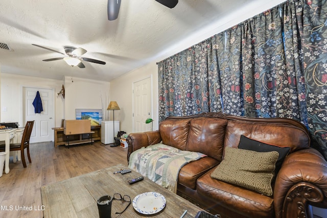 living room featuring hardwood / wood-style flooring, a textured ceiling, and ceiling fan