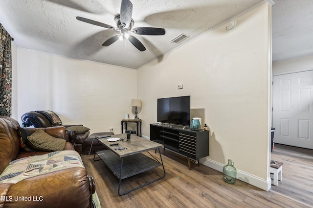 living room featuring hardwood / wood-style flooring, a textured ceiling, and ceiling fan