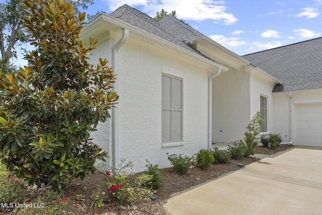 119 Paylors Way, Madison, MS 39110 - view of side of home featuring a shingled roof, an attached garage, brick siding, and driveway