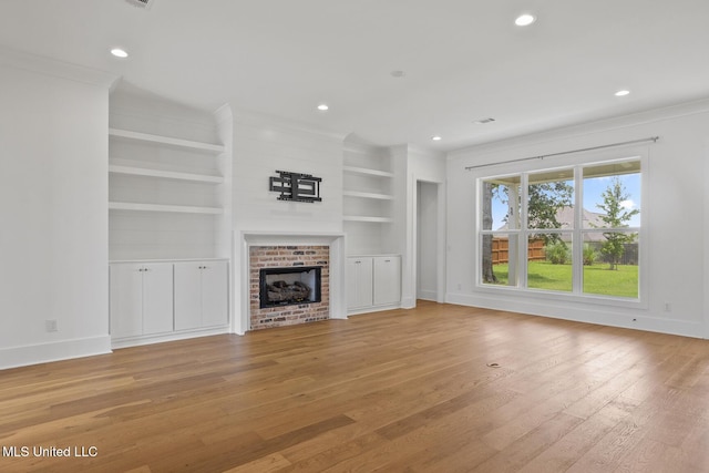 119 Paylors Way, Madison, MS 39110 - unfurnished living room with light wood-style flooring, recessed lighting, a brick fireplace, ornamental molding, and built in features