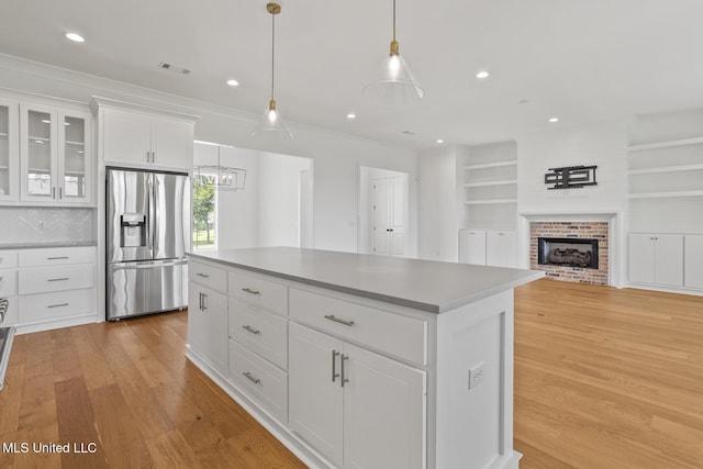 119 Paylors Way, Madison, MS 39110 - kitchen featuring stainless steel fridge, light wood finished floors, white cabinetry, a kitchen island, and pendant lighting