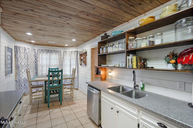 kitchen featuring dishwasher, wood ceiling, wooden walls, sink, and white cabinets