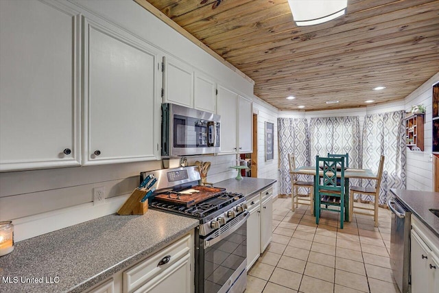 kitchen featuring appliances with stainless steel finishes, wood ceiling, white cabinetry, and light tile patterned flooring