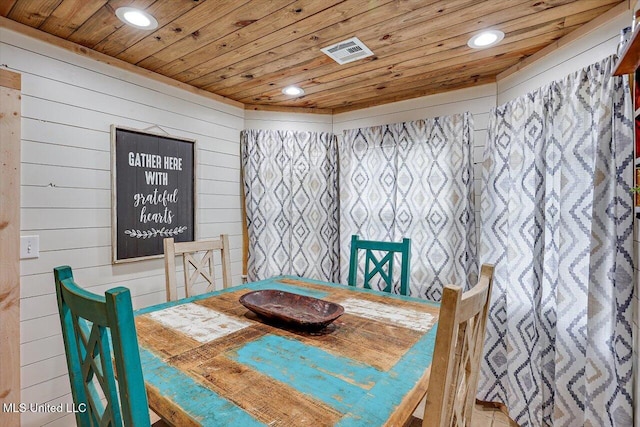 dining room featuring wooden walls and wooden ceiling