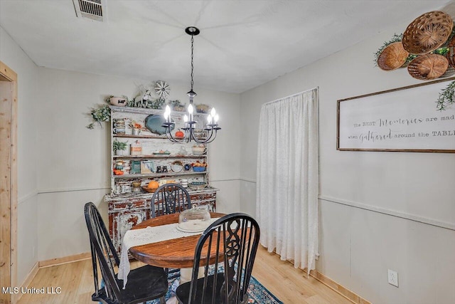 dining space featuring a chandelier and light wood-type flooring