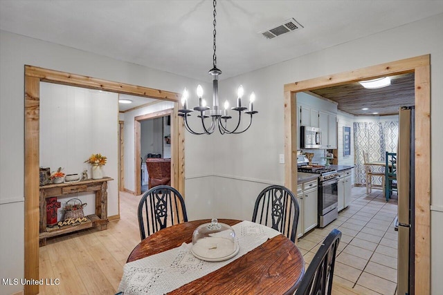 dining area with an inviting chandelier and light hardwood / wood-style flooring