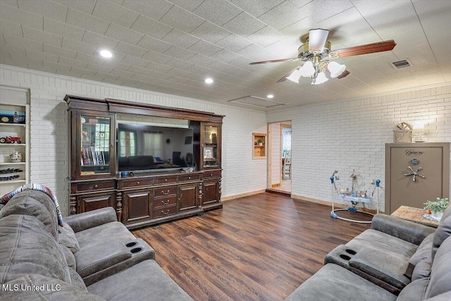 living room featuring ceiling fan, brick wall, and dark hardwood / wood-style flooring