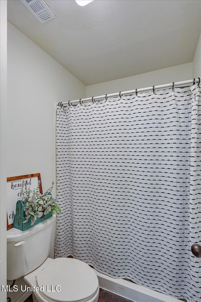 bathroom featuring toilet and a shower with shower curtain