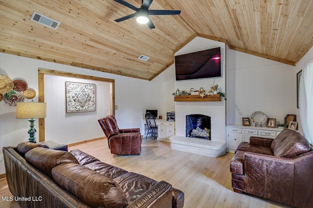 living room with light hardwood / wood-style flooring, a brick fireplace, wood ceiling, and vaulted ceiling