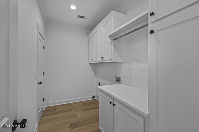 washroom with crown molding, hardwood / wood-style floors, cabinets, washer hookup, and hookup for an electric dryer