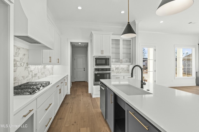 kitchen with sink, white cabinetry, hanging light fixtures, stainless steel appliances, and custom exhaust hood