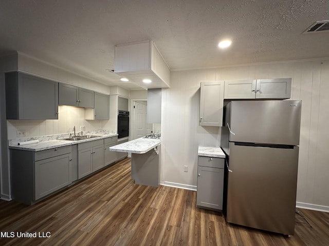 138 William Mckinley Cir, Jackson, MS 39213 - kitchen featuring appliances with stainless steel finishes, gray cabinets, a sink, dark wood-style floors, and a textured ceiling