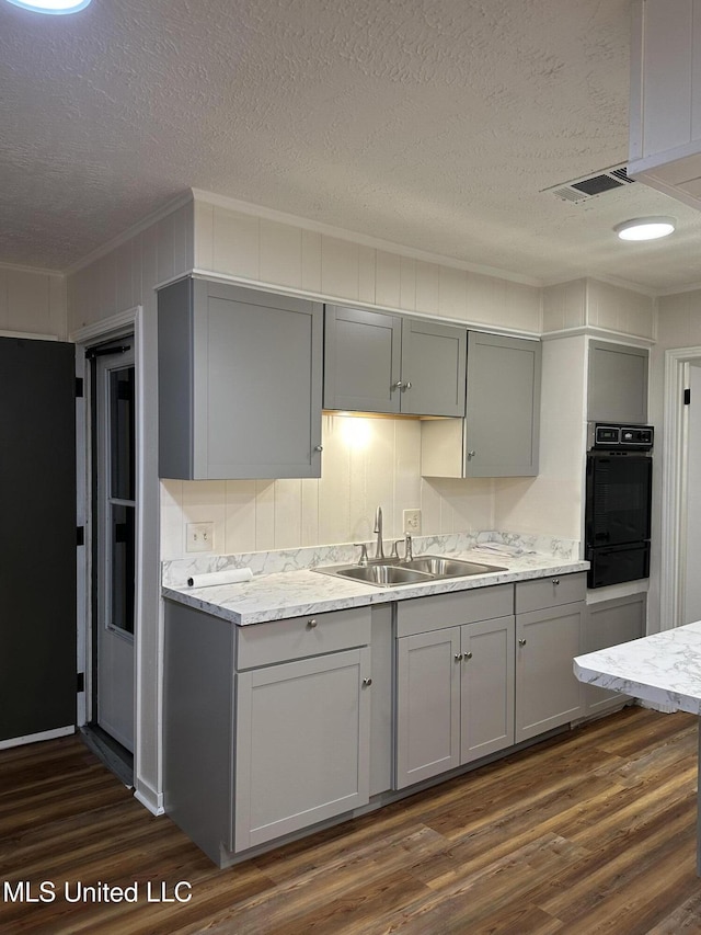 138 William Mckinley Cir, Jackson, MS 39213 - kitchen with oven, gray cabinetry, a sink, a textured ceiling, and ornamental molding