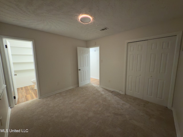 138 William Mckinley Cir, Jackson, MS 39213 - unfurnished bedroom with light colored carpet, a closet, baseboards, ensuite bathroom, and a textured ceiling