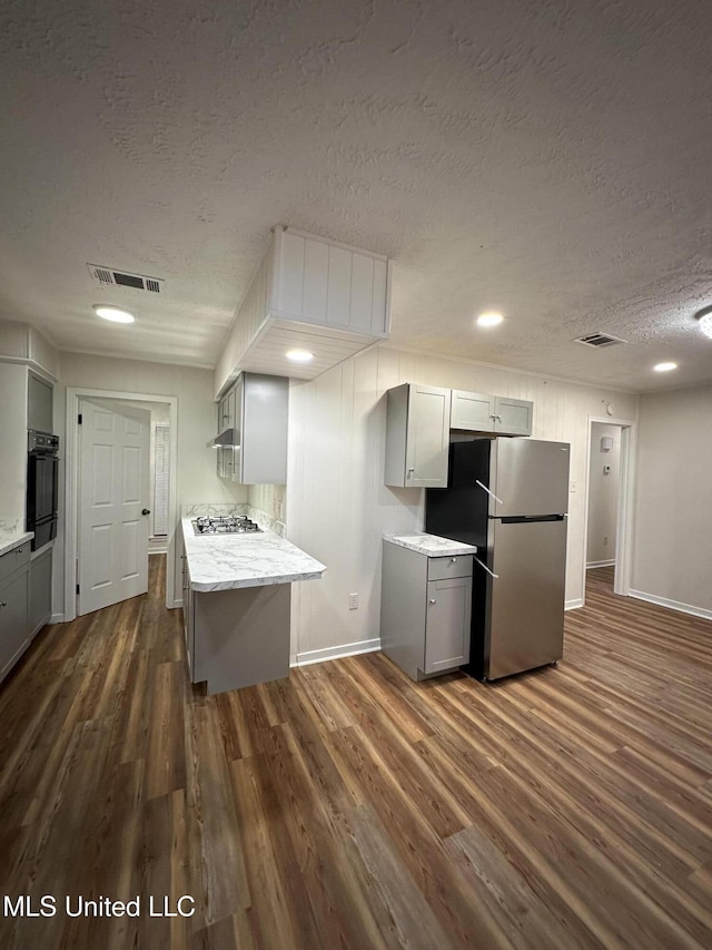 138 William Mckinley Cir, Jackson, MS 39213 - kitchen with appliances with stainless steel finishes, gray cabinetry, a textured ceiling, dark wood-type flooring, and baseboards