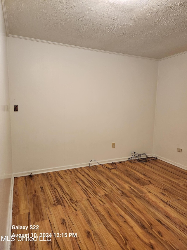 spare room with a textured ceiling and hardwood / wood-style flooring