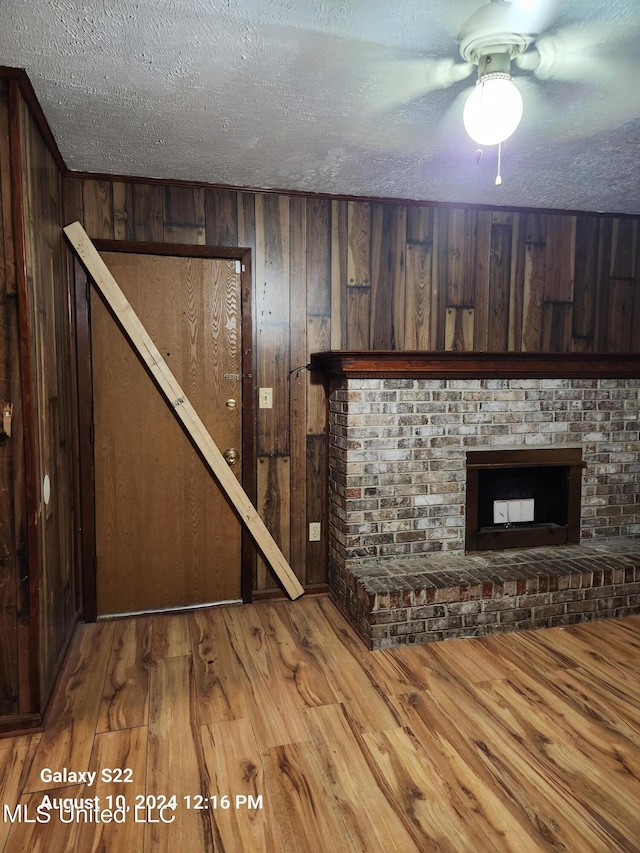 interior space with a textured ceiling, a fireplace, and wood-type flooring