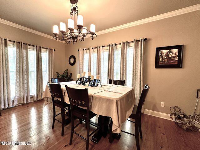 139 Glen Auburn Dr, Clinton, MS 39056 - dining room with a chandelier, dark wood-type flooring, baseboards, and ornamental molding