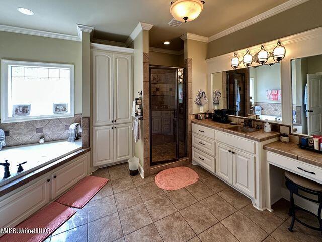 139 Glen Auburn Dr, Clinton, MS 39056 - bathroom featuring a stall shower, crown molding, vanity, a bath, and tile patterned flooring