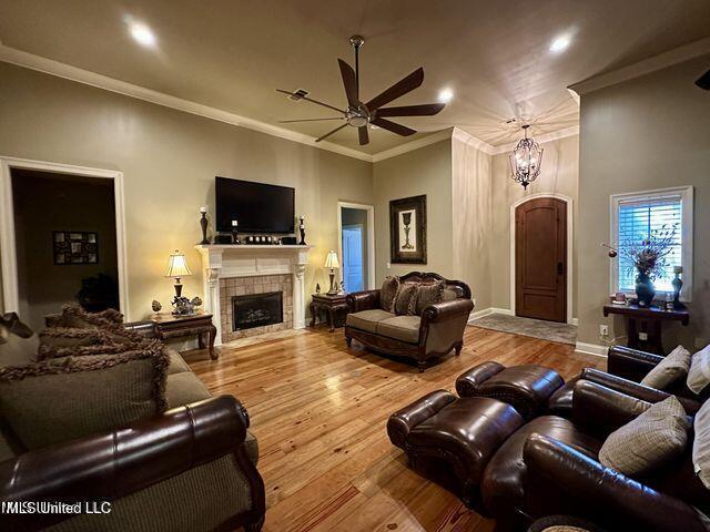 139 Glen Auburn Dr, Clinton, MS 39056 - living area with a ceiling fan, a tiled fireplace, crown molding, wood finished floors, and recessed lighting
