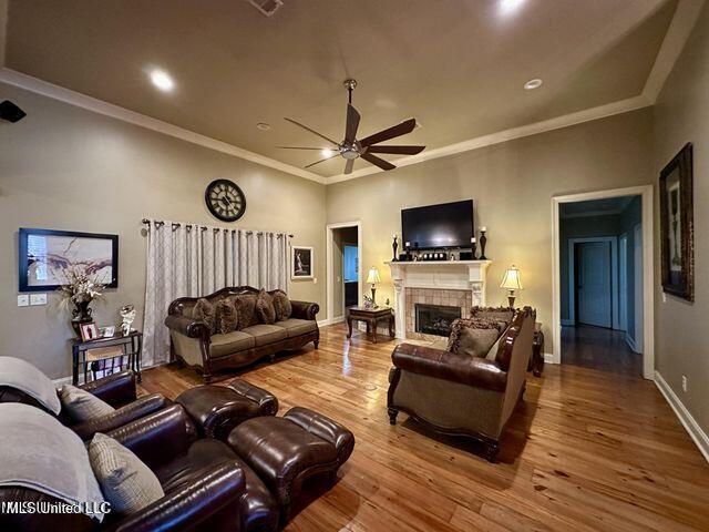 139 Glen Auburn Dr, Clinton, MS 39056 - living room with a ceiling fan, a fireplace, ornamental molding, wood finished floors, and baseboards