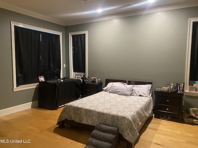 bedroom featuring light wood-style flooring and crown molding