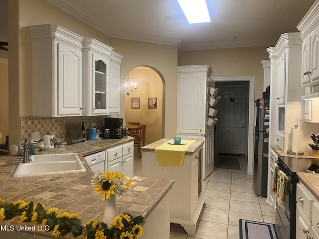 kitchen featuring a sink, freestanding refrigerator, arched walkways, black electric range oven, and ornamental molding