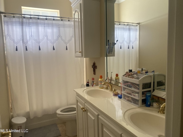 bathroom featuring toilet, shower / bath combo with shower curtain, double vanity, and a sink