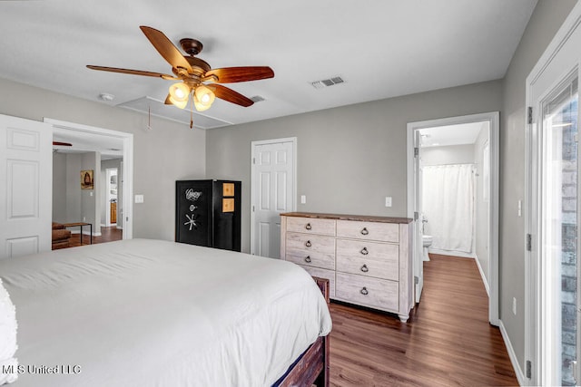 bedroom featuring dark wood-style flooring, visible vents, attic access, ceiling fan, and baseboards