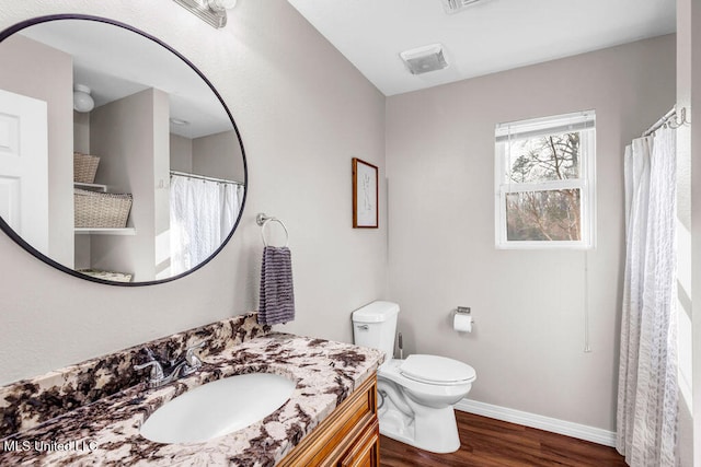 full bathroom featuring toilet, wood finished floors, visible vents, vanity, and baseboards