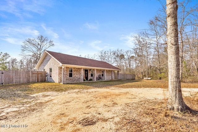 view of front of house with brick siding and fence