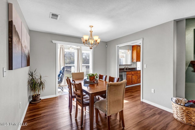 dining area featuring baseboards, dark wood-style flooring, visible vents, and an inviting chandelier