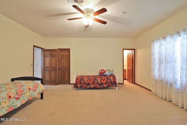 carpeted bedroom featuring multiple windows, a textured ceiling, and ceiling fan