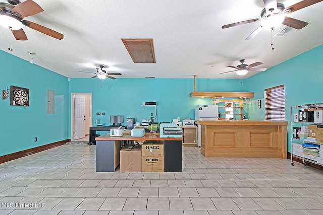 kitchen with white fridge, a textured ceiling, light tile patterned flooring, and a kitchen island