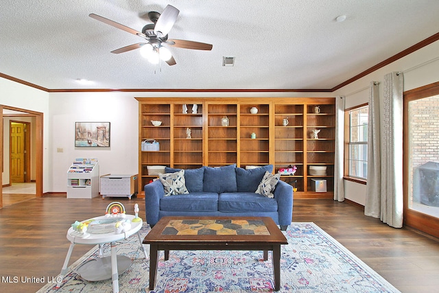 living room with ornamental molding, ceiling fan, a textured ceiling, and dark hardwood / wood-style flooring