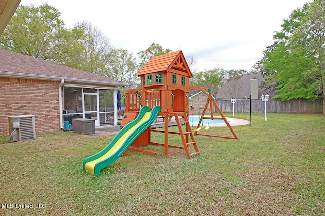 view of play area with cooling unit, a swimming pool, a yard, and a sunroom