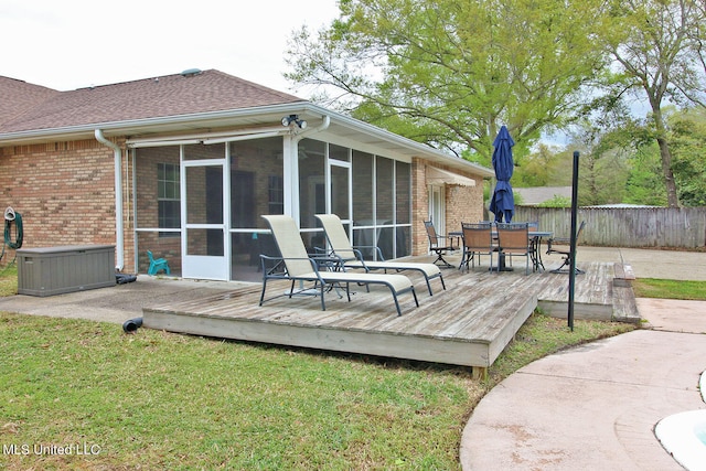 deck with a yard and a sunroom