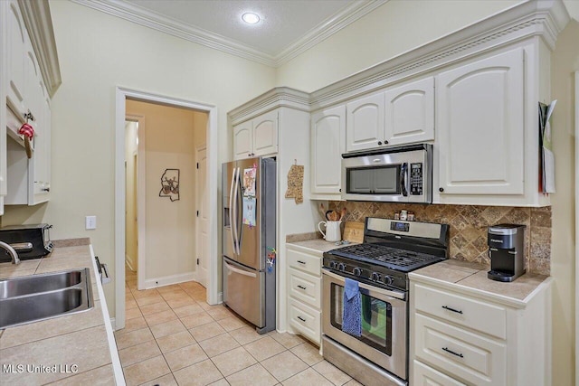 kitchen featuring light tile patterned floors, decorative backsplash, crown molding, a sink, and appliances with stainless steel finishes