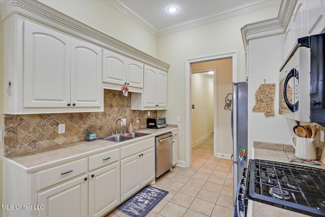 kitchen with a sink, stainless steel appliances, backsplash, tile countertops, and ornamental molding
