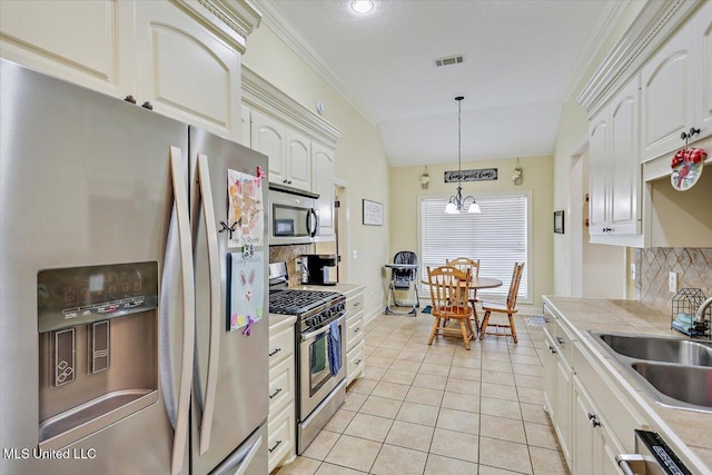 kitchen featuring a sink, decorative light fixtures, appliances with stainless steel finishes, and decorative backsplash