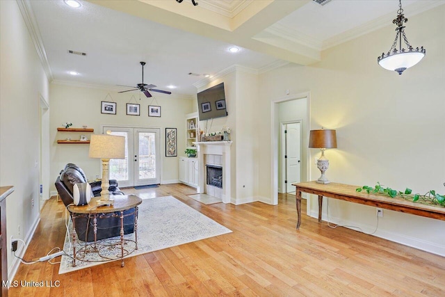 living room with visible vents, ornamental molding, and ceiling fan