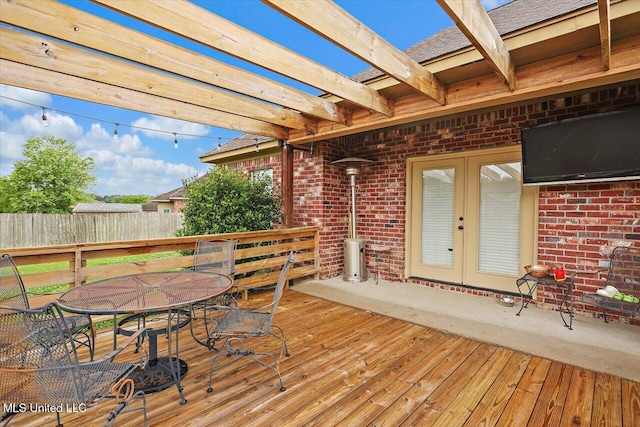 wooden deck with a pergola, outdoor dining area, french doors, and fence
