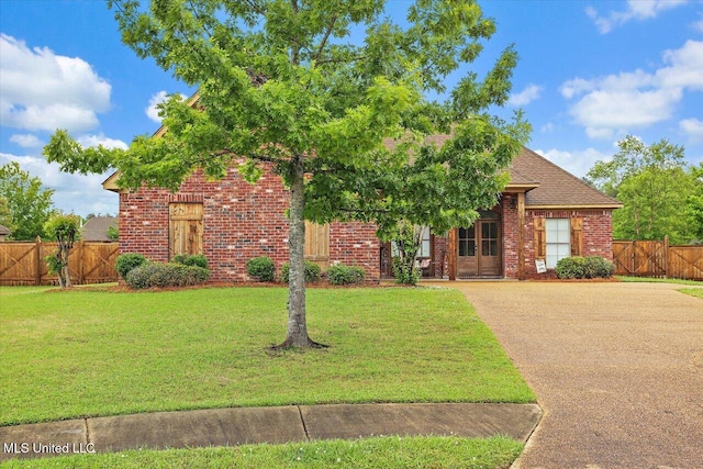 view of front of house with fence, a gate, a front yard, and brick siding