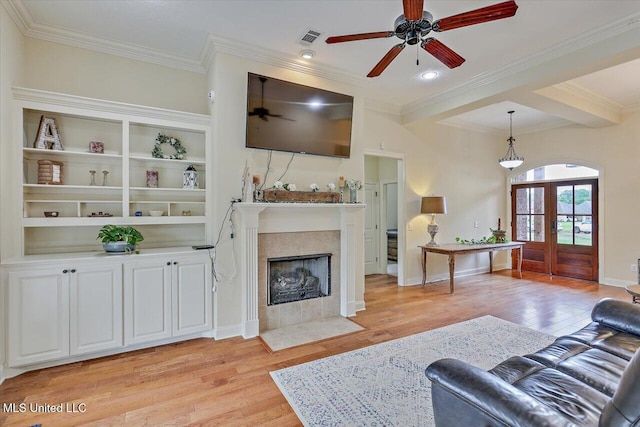 living area with visible vents, ceiling fan, crown molding, and light wood-style flooring